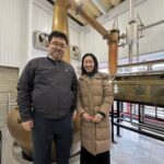 A moment of 'Hitsuzen' (Inevitability) at Kameda Distillery: Mika Tanimoto and President Tokida standing before the copper pot stills that craft Niigata's most 'beautiful' whisky