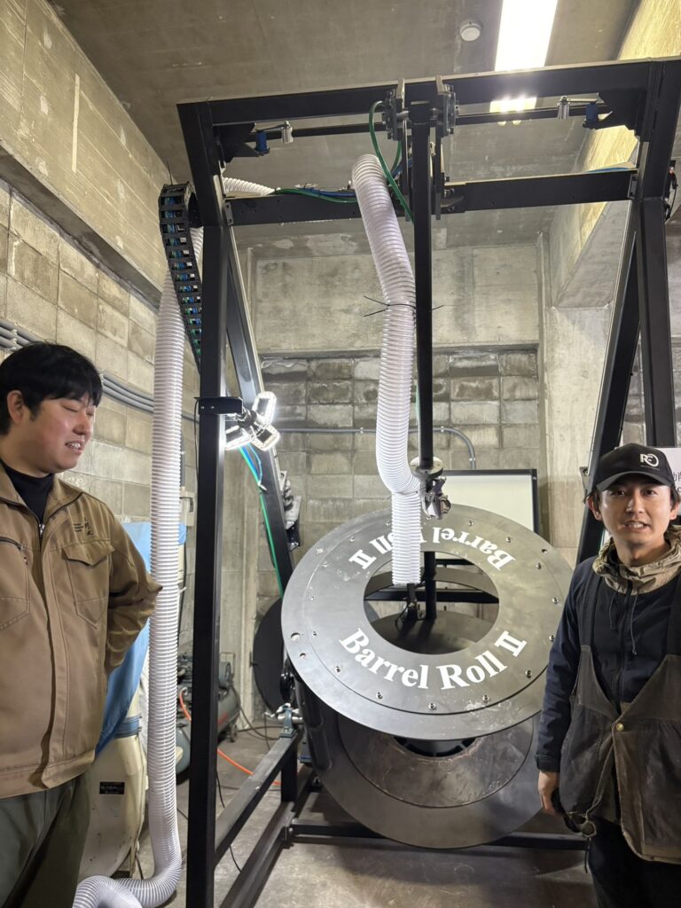 President Takahiko Inagaki of Saburomaru Distillery with a cooper and his invention, 'Barrel Roll 2,' showcasing the heart of Japanese whisky innovation to Mika Tanimoto.